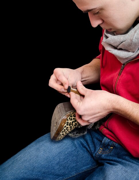 Shoemaker, der ein altes Paar Schuhe repariert