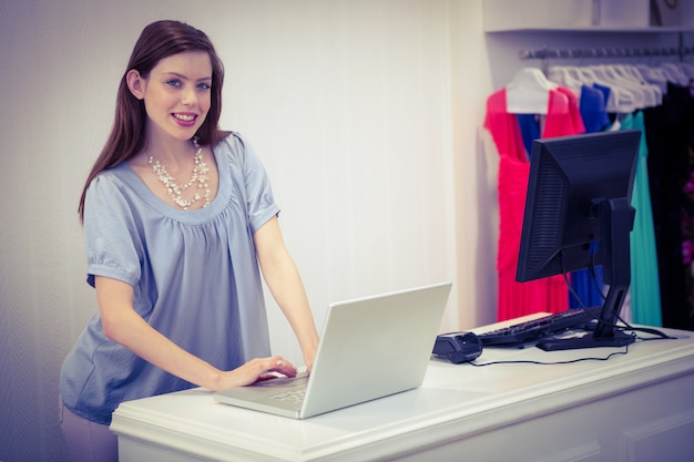 Shop-Arbeiter mit Laptop an der Kasse