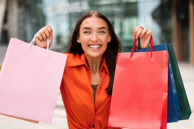 Shopaholic mit bunten Einkaufstüten im Stadtgebiet