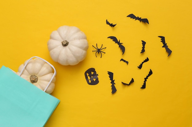 Shopping-Papiertüte mit Halloween-Dekor auf gelbem Hintergrund Halloween-Shopping-Draufsicht
