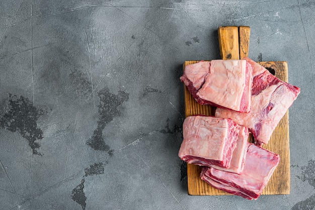 Short Ribs Bone In Eintopf, auf grauem Steinhintergrund, Draufsicht flach, mit Kopierraum für Text