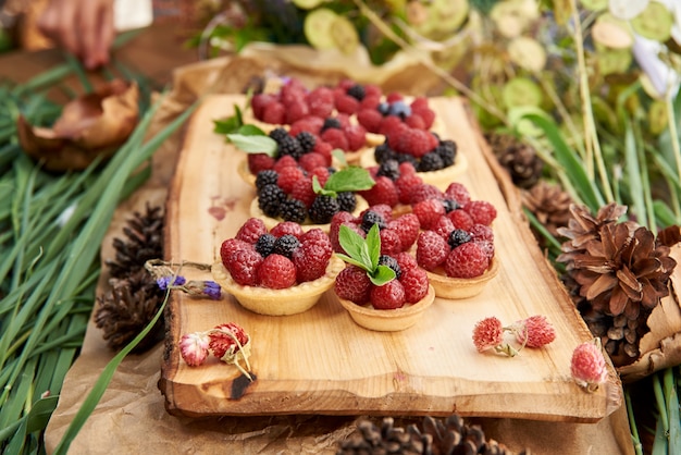 Shortbread-Körbe mit Quarkcreme und Beeren auf einer Holzmatte