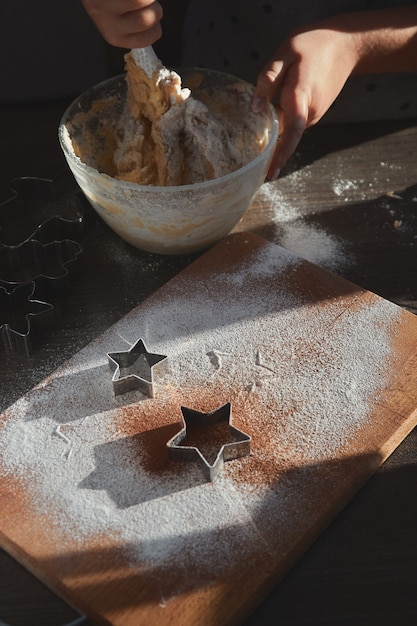Shortbread Teig für Lebkuchen Kekse auf dem Holzbrett gerollt. Sternförmige Kekse ausschneiden.