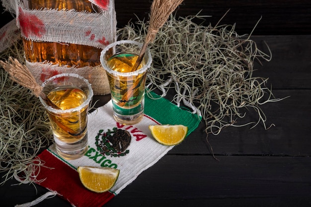 shots de tequila com decoração de halloween, óculos com rostos assustadores e vassouras de bruxa