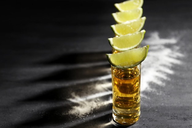 Foto shots de tequila ouro com limão e sal em fundo cinza