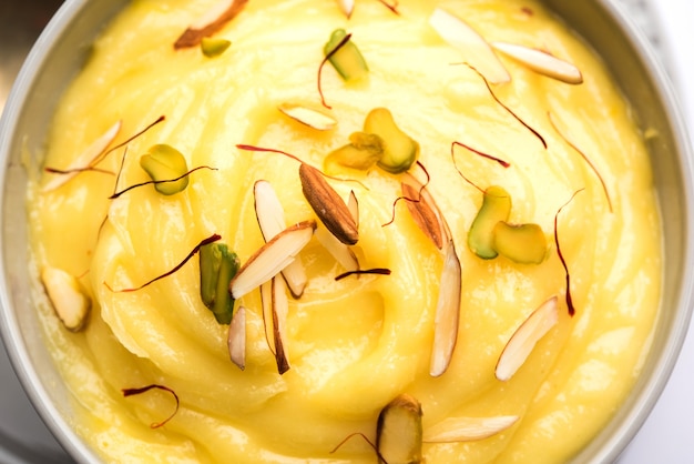 Shrikhand OR Srikhand ist ein indisches Dessert aus passiertem Joghurt, garniert mit Trockenfrüchten und Safran.