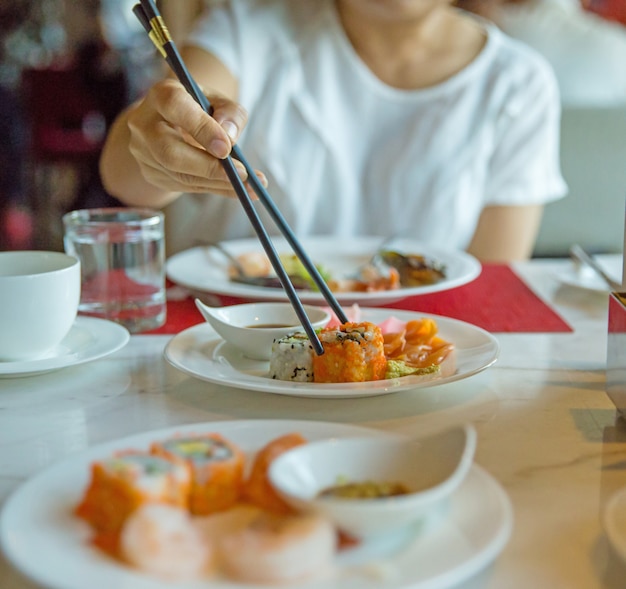 Shushi mit essstäbchen essen, konzentrieren sie sich selektiv