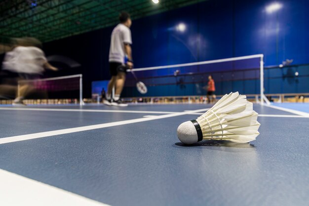 Shuttle cock badminton en la cancha azul jugando bádminton.