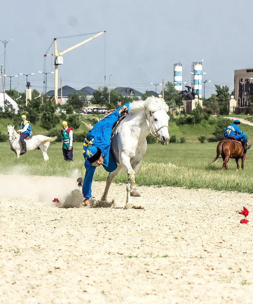 Shymkent Kazajstán 16 de mayo de 2018 Una fiesta en el hipódromo de la ciudad en honor al comienzo del mes sagrado de Ramadán jinetes en trajes nacionales a caballo