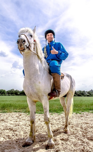 Shymkent Kazajstán 16 de mayo de 2018 Una fiesta en el hipódromo de la ciudad en honor al comienzo del mes sagrado de Ramadán jinetes en trajes nacionales a caballo
