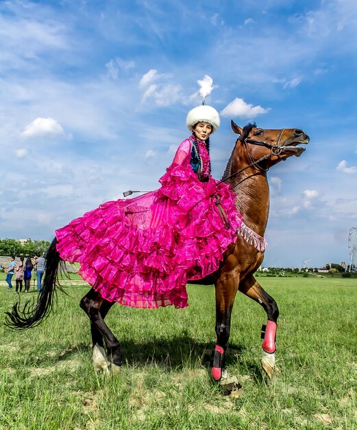 Shymkent Kazajstán 16 de mayo de 2018 Una fiesta en el hipódromo de la ciudad en honor al comienzo del mes sagrado de Ramadán Niñas con trajes nacionales a caballo