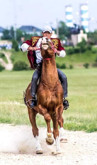 Shymkent Kazakhstan 16 de maio de 2018 Um feriado no hipódromo da cidade em homenagem ao início do mês sagrado do Ramadã Cavaleiros em trajes nacionais a cavalo