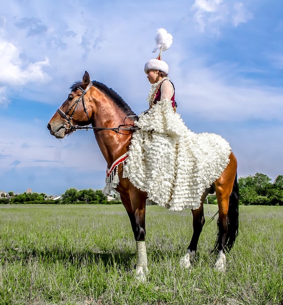 Shymkent Kazakhstan 16 de maio de 2018 Um feriado no hipódromo da cidade em homenagem ao início do mês sagrado do Ramadã Meninas em trajes nacionais a cavalo