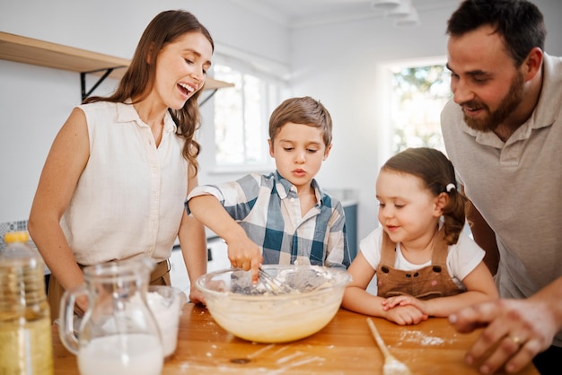 Foto si está hecho con amor, seguramente será delicioso foto de una pareja y sus dos hijos horneando juntos en casa