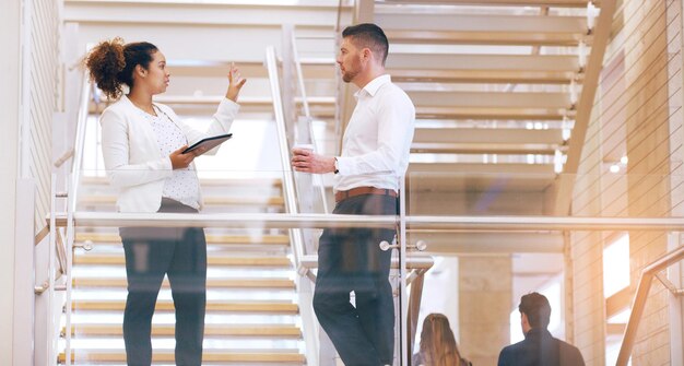 Si lo miramos desde esa perspectiva Captura recortada de dos jóvenes empresarios discutiendo mientras están parados en un lugar de trabajo moderno