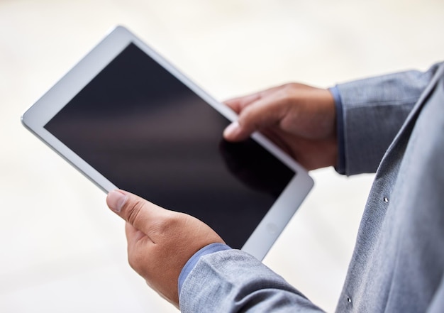 Foto si tiene acceso a internet, tiene acceso al éxito captura recortada de un hombre irreconocible usando una tableta digital