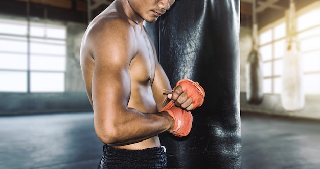 Ásia muay thai com ataduras de boxe com luva de boxe, preparando-se para o treinamento de lutador.