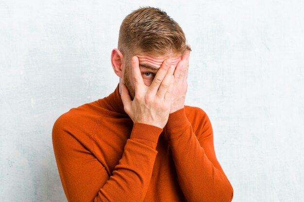 Foto sich ängstlich oder verlegen fühlen, mit halb mit händen bedeckten augen spähen oder spionieren