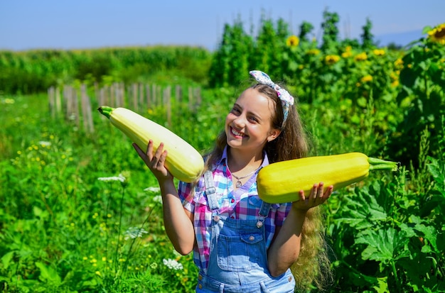 Sich um die Natur kümmern kleines Mädchen Landwirtschaft im Sommer Bauernhof glücklicher Kindertag Kindheit Glück Porträt eines glücklichen Kindes mit Gemüsemark fröhliches Retro-Kind hält großen Markkürbis