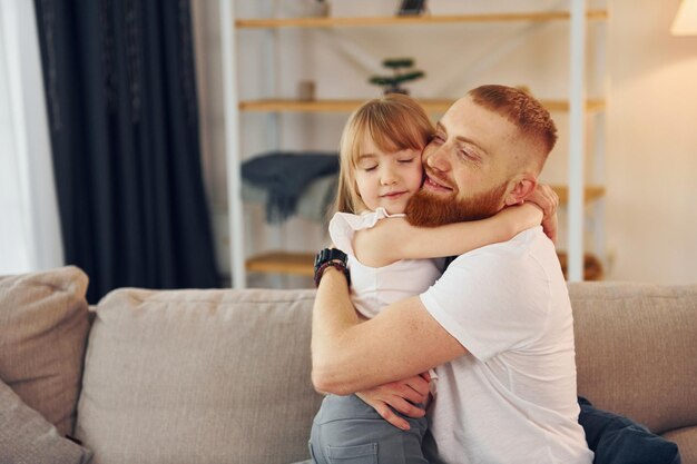 Sich umarmen Vater mit seiner kleinen Tochter ist zusammen zu Hause