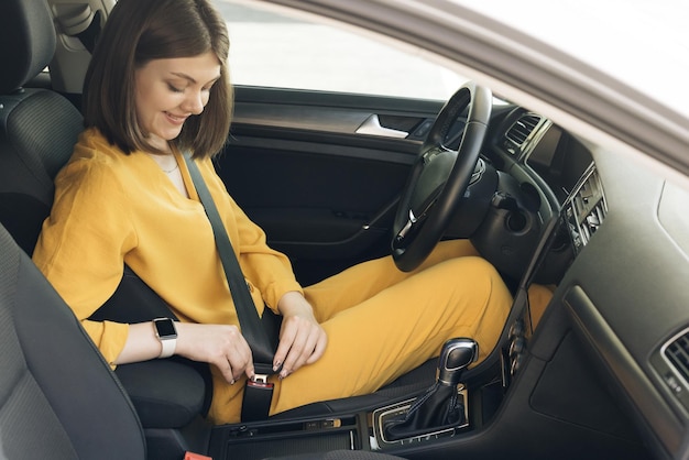 Sicherheit erste schöne kaukasische Dame, die Autosicherheitsgurt befestigt Geschäftsfrau, die in einem Auto sitzt