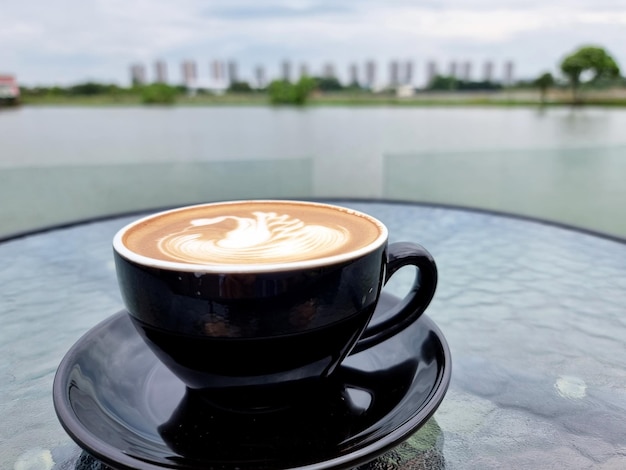 Sideway Shop Coffee eine Tasse heißen Latte Art Kaffee auf dem öffentlichen Teich Hintergrund