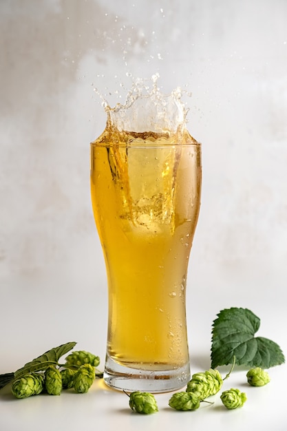 Sidra de lúpulo en un vaso sobre un fondo gris