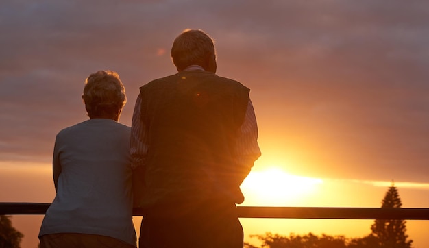 Sie lieben immer noch Romantik Schnappschuss eines älteren Paares, das einen romantischen Moment bei Sonnenuntergang teilt