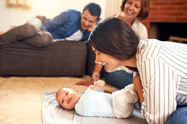 Sie liebt ihren kleinen Jungen. Schnappschuss einer attraktiven jungen Frau und ihres kleinen Jungen, der sich zu Hause mit der Familie im Hintergrund verbindet