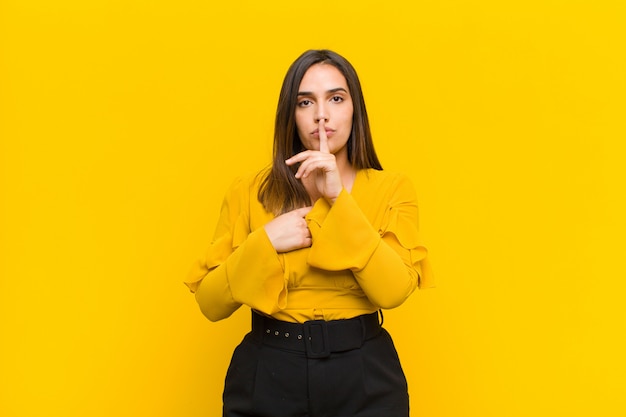 Sie sehen ernst aus und kreuzen sich mit einem Finger, der an die Lippen gedrückt wird, um Stille oder Ruhe zu fordern und ein Geheimnis zu bewahren