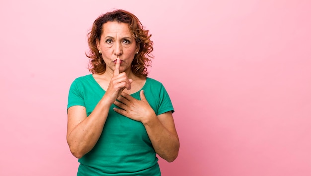 Sie sehen ernst aus und kreuzen sich mit einem Finger, der an die Lippen gedrückt wird