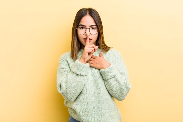 Sie sehen ernst aus und kreuzen sich mit einem Finger, der an die Lippen gedrückt wird