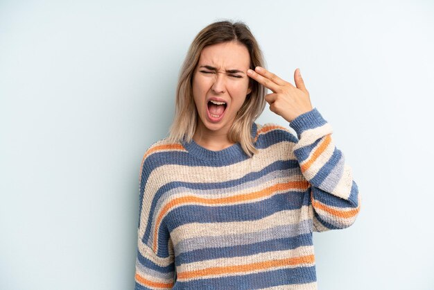 Sie sehen unglücklich und gestresste Selbstmordgeste aus und machen ein Waffenzeichen mit der Hand auf den Kopf zeigend