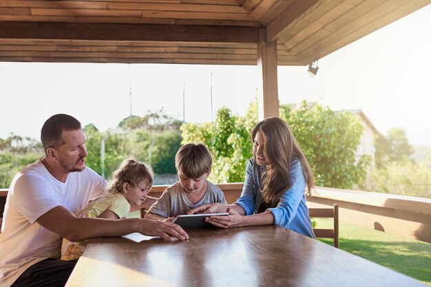 Sie sind eine verbundene Familie Aufnahme einer Familie, die gemeinsam im Freien ein digitales Tablet verwendet