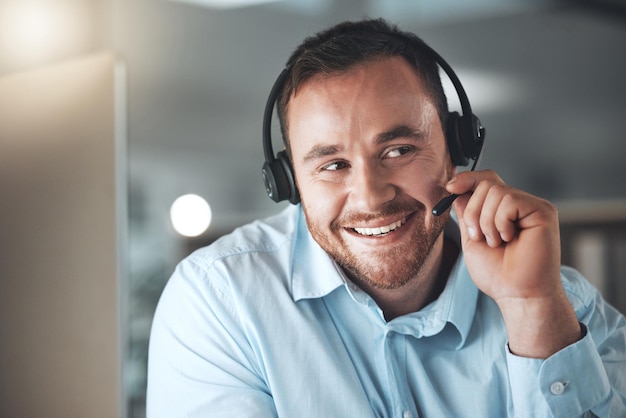 Sie sprechen mit einem unserer freundlichen Agenten Aufnahme eines jungen Call-Center-Agenten, der allein in seinem Büro sitzt und seinen Computer benutzt