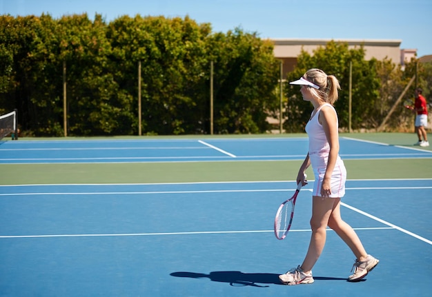 Sie verbringt jeden Tag auf dem Platz Eine junge Tennisspielerin draußen auf dem Platz