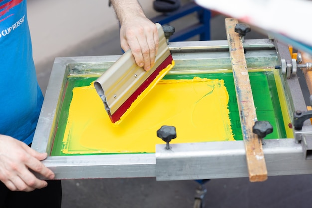 Siebdruckverfahren in der Kleiderfabrik. Rahmen-, Rakel- und Plastisolfarben.