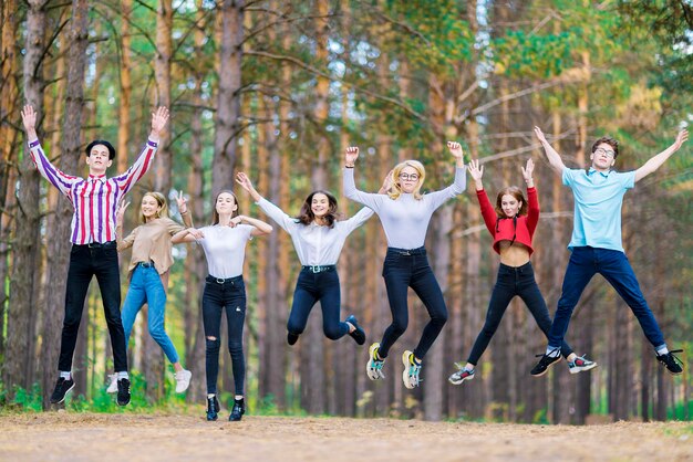 Sieben springende Teenager im Alter von 1519 Jahren im Sommerwald