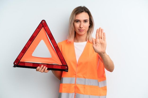 Sieht ernst aus und zeigt eine offene Handfläche, die eine Stopp-Geste macht