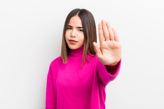 Sieht ernst, streng, unzufrieden und wütend aus und zeigt eine offene Handfläche, die eine Stopp-Geste macht