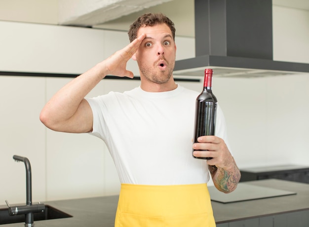 Foto sieht glücklich, erstaunt und überrascht aus. konzept einer flasche wein