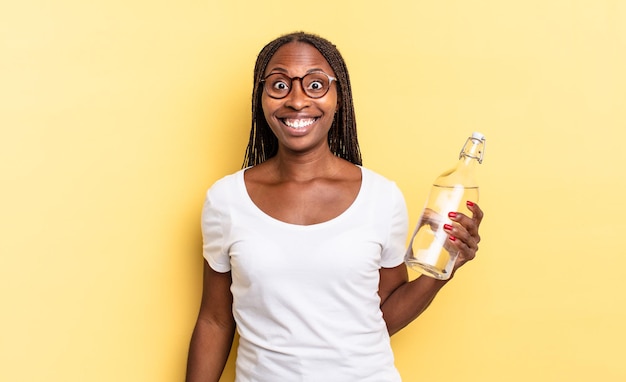 Sieht glücklich und angenehm überrascht aus, aufgeregt mit einem faszinierten und schockierten Ausdruck. Wasserflaschenkonzept