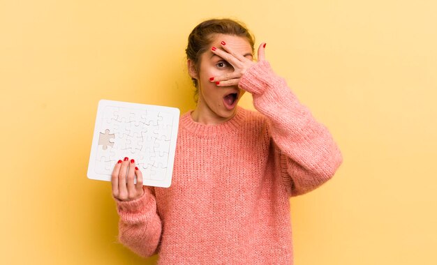 Sieht schockiert, verängstigt oder verängstigt aus und bedeckt das Gesicht mit der Hand