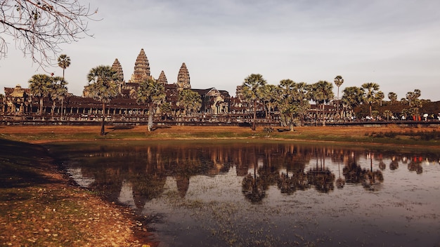 Siem reap, camboja, fevereiro de 2014: algumas pessoas visitam as ruínas de pedra do maior monumento religioso do complexo do templo de angkor wat e patrimônio mundial da unesco