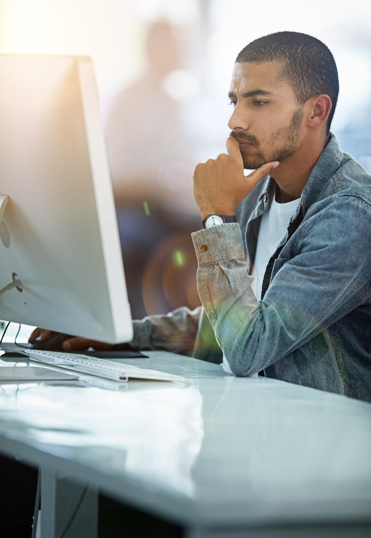 Foto siempre le da a su trabajo un enfoque del cien por cien foto de un joven diseñador sumido en sus pensamientos mientras trabaja en una computadora en una oficina moderna