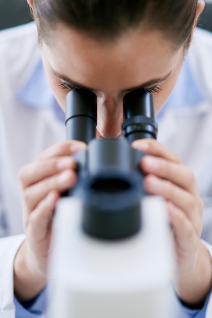 Siempre hay algo nuevo por descubrir Captura recortada de una joven científica usando un microscopio en un laboratorio