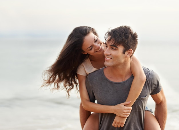 Siempre te cuido, nena Captura recortada de una cariñosa pareja joven en la playa