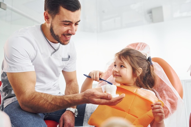 Se sienta en la silla Niña visitando al dentista en la clínica Concepción de estomatología