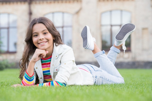 Siéntase libre y seguro Niño feliz relajarse en la hierba verde Aspecto de belleza de niña Peluquería Cuidado de niños e infancia Actividades de ocio y tiempo de juego Vacaciones de verano Día internacional del niño