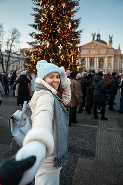 Siga-me conceito mulher puxando o homem para a árvore de natal